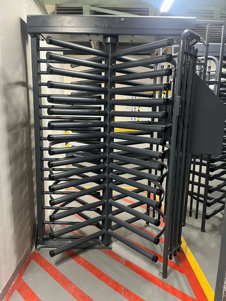 IHD full height turnstile installed on a hazard-striped floor